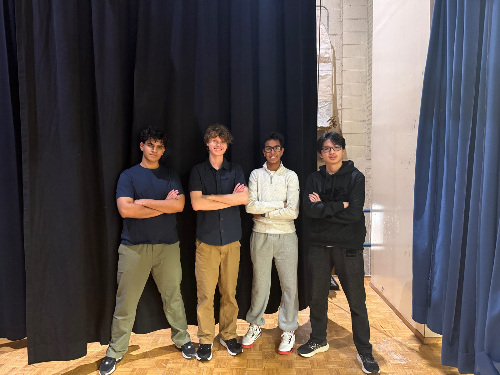 The STEMroots team standing together in a school gym